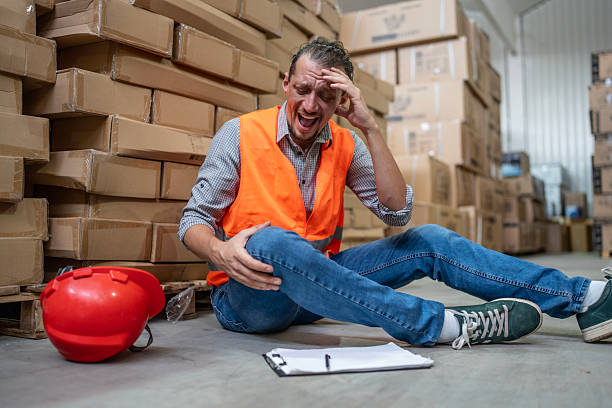 istock Worker in Warehouse Experiencing an Accident While Sitting on the Floor 2232528191