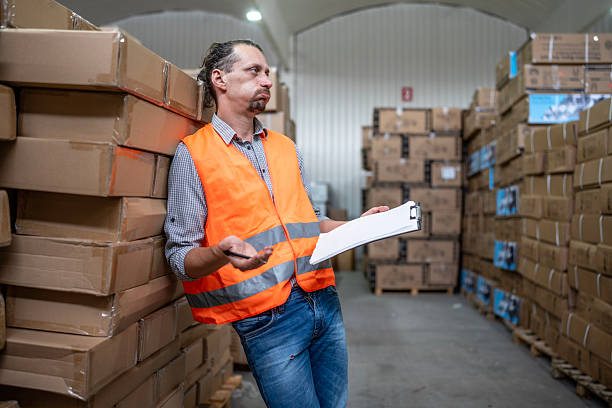 istock Warehouse Worker Managing Inventory with a Clipboard and Safety Vest 2232528278