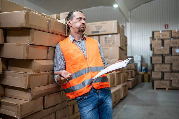 istock Warehouse Worker Reviewing Inventory Data on Clipboard in Storage Facility 2232528287