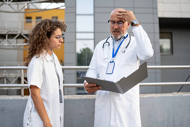 istock Concerned Medical Professionals Reviewing Patient Data Outdoors in a Modern Setting 2232528787