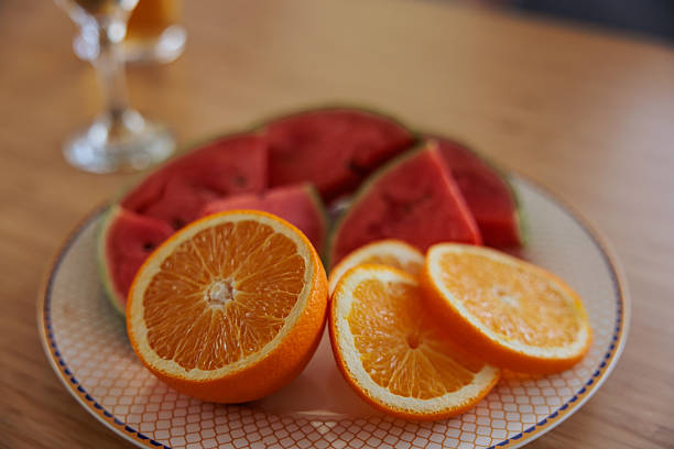 Close-up shot of a plate filled with fresh orange and watermelon slices, highlighting vibrant colors and refreshing fruit details.