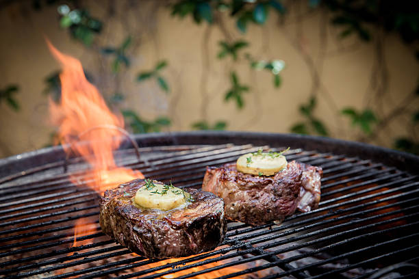 istock Juicy Steaks Grilling Over Open Flame with Herb Butter Topping 2232530633