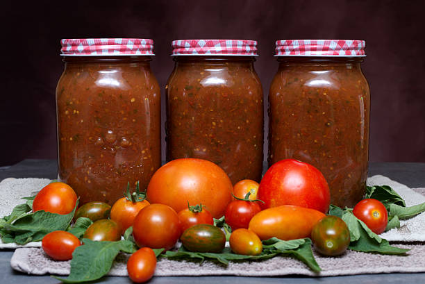 istock Jars of Tomato Sauce with Fresh Tomatoes and Basil on a Rustic Background 2232530765