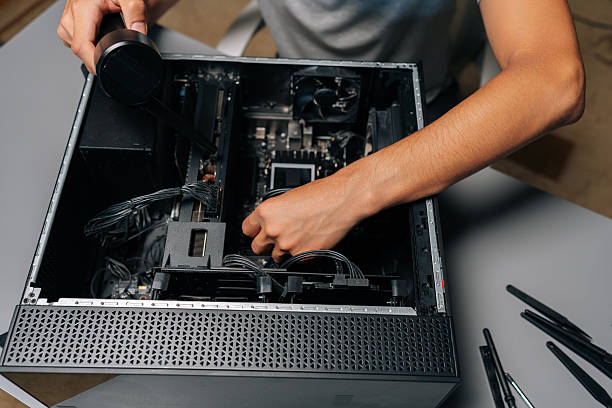 istock Top view of computer repair professional cleaning computer interior with vacuum preventing dust accumulation and potential hardware damage. 2232531826