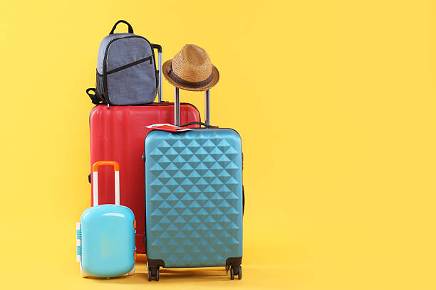 istock Travel abroad. Packed suitcases, backpack and hat on yellow background, space for text 2232531916