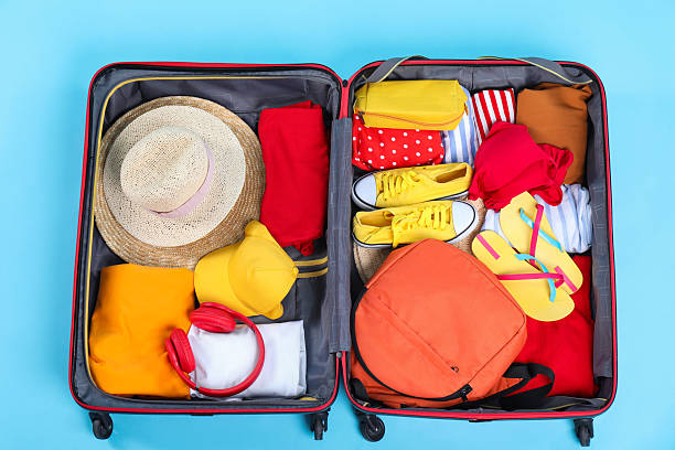 istock Travel abroad. Packed suitcase on light blue background, top view 2232531978