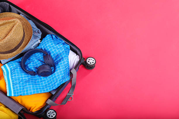 istock Travel abroad. Packed suitcase on red background, above view. Space for text 2232532036