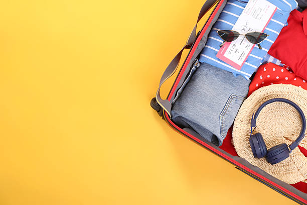 istock Travel abroad. Packed suitcase on yellow background, top view. Space for text 2232532070