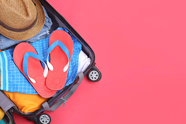 istock Travel abroad. Packed suitcase on red background, top view. Space for text 2232532135