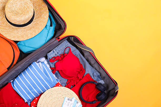 istock Travel abroad. Packed suitcase on yellow background, top view. Space for text 2232532218