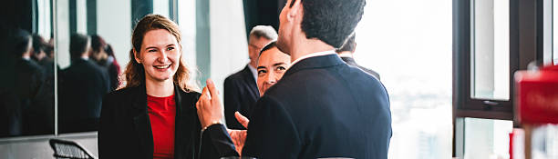 istock Business professionals network by coffee station in modern office. Workplace conversation shows colleagues meeting, teamwork, and collaboration during a friendly break with city views. 2232532957