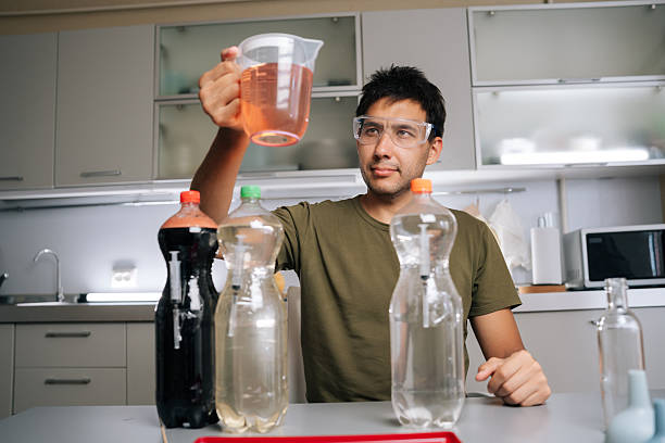 istock Chemist wearing safety glasses holding beaker with liquid fertilizer, prepared from various chemicals in laboratory, emphasizing fertilizer preparation 2232535775
