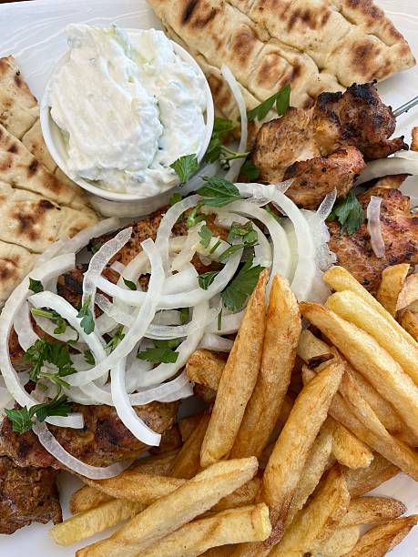 Greece - food - Souvlaki. It is a Greek food item consisting of small pieces of meat and sometimes vegetables grilled on a skewer. It is usually eaten straight off the skewer while still hot. It can be served with or inside a rolled pita, typically with lemon, sauces, vegetables such as sliced tomato and onion, and fried potatoes as a side.