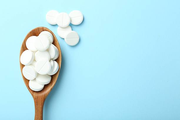 istock Antibiotic pills and spoon on light blue background, flat lay. Space for text 2232536823