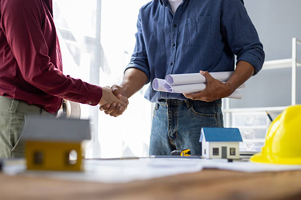 istock Architect holding blueprints is shaking hands with a client in his office during a meeting about a real estate project. 2232538175