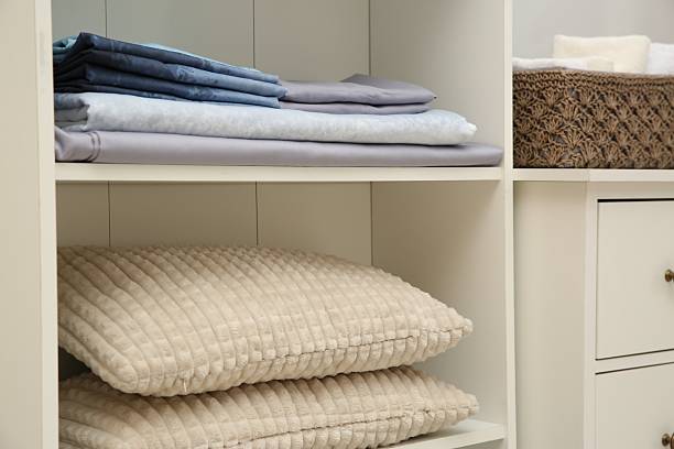 istock Home textile organization. Folded bedsheets and pillows on shelving unit indoors, closeup 2232539129