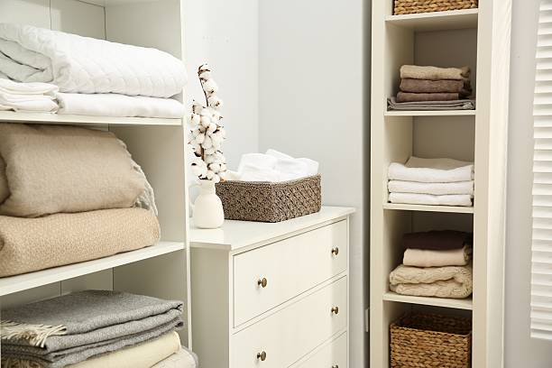 Home textile organization. Folded towels and blankets on shelving units indoors