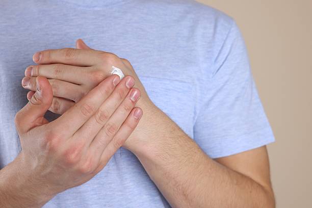 istock Man applying hand cream on beige background, closeup 2232539670