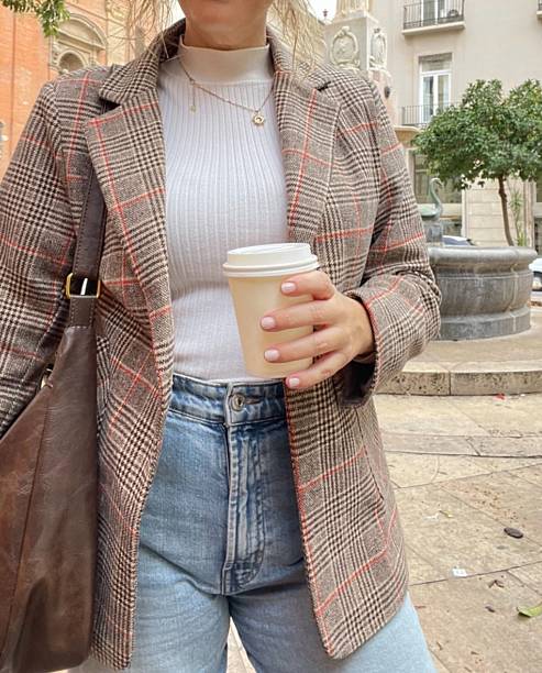 istock Influencer wearing a plaid blazer drinking coffee on the street. 2232539911