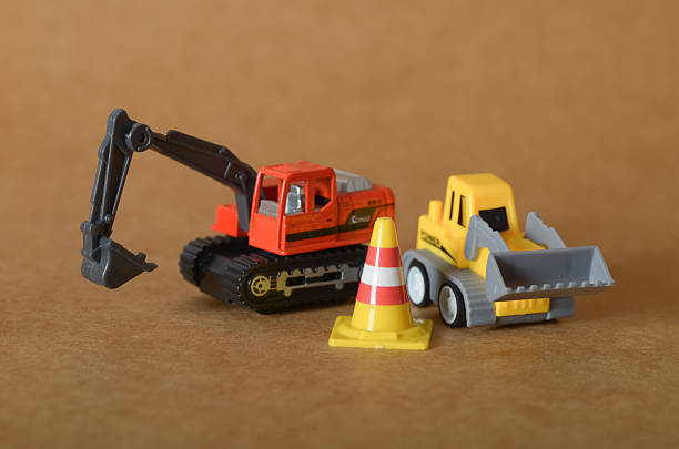 istock Heavy Equipment at Work: Orange Excavator and Yellow Loader in a Miniature Construction Zone. 2232542629