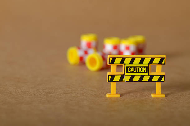 Prominent 'CAUTION' barrier with a blurred background indicating a potential hazard zone.
