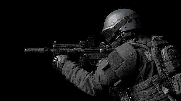 istock soldier is poised with a firearm, showcasing a tactical stance in a dark setting. scene highlights the soldiers dedication to training and readiness for missions. 3d render 2232542923