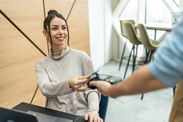 istock Smiling customer paying with contactless credit card in cafe 2232543488