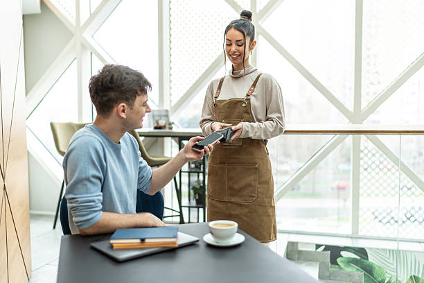 istock Customer paying with smartphone in modern cafe 2232543642