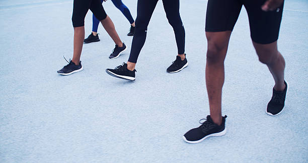istock Active, people and running on road, legs or training for marathon together, race or workout routine. Athlete, feet and group with footwear for cardio, exercise and preparing for sport competition 2232545163