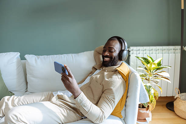 istock Smiling man watching video on smartphone 2232552037