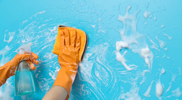 istock Woman hand cleaning blue wall with rag and spray bottle 2232554151