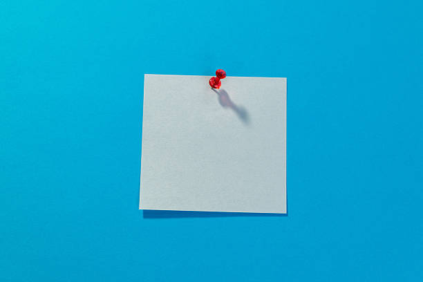 istock Blank white sticky note and red thumbtack on blue background 2232554509