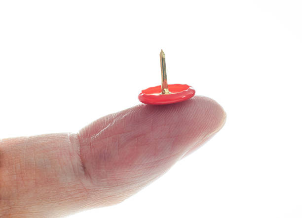 istock Close-up of hand holding a red pushpin 2232554677