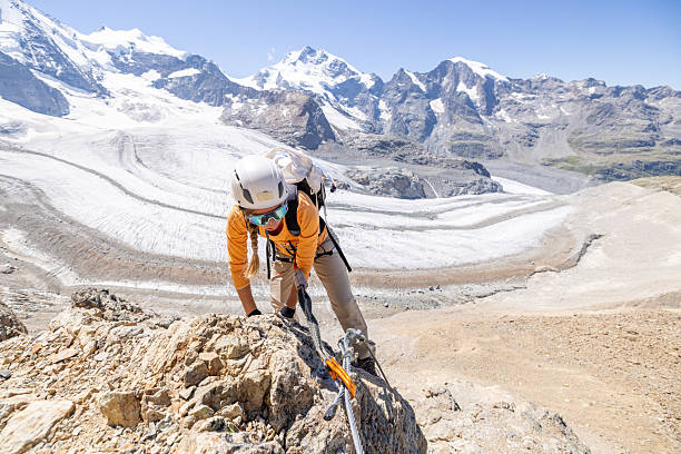istock Woman Climbing Rocky Mountain with Glacier View 2232555468