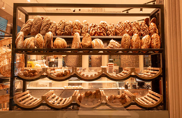 istock Rustic bread loaves displayed on shelves inside a bakery shop. 2232556317