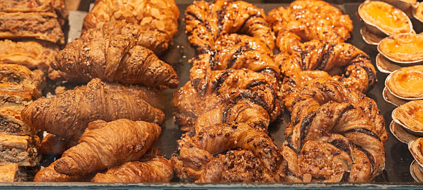 istock Assorted croissants, puff pastries and custard tarts displayed in bakery showcase. 2232556396