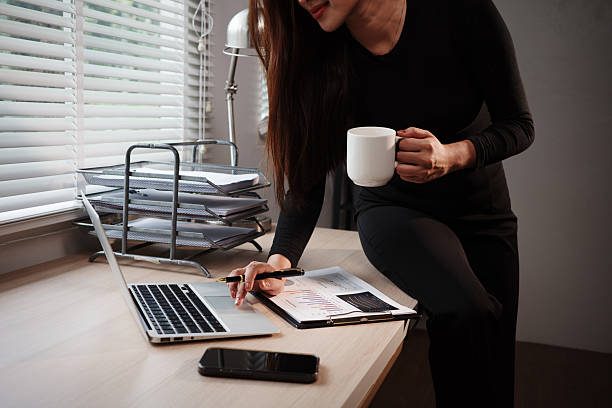 istock Businesswoman working with laptop and analyzing financial charts while drinking coffee in office 2232559047