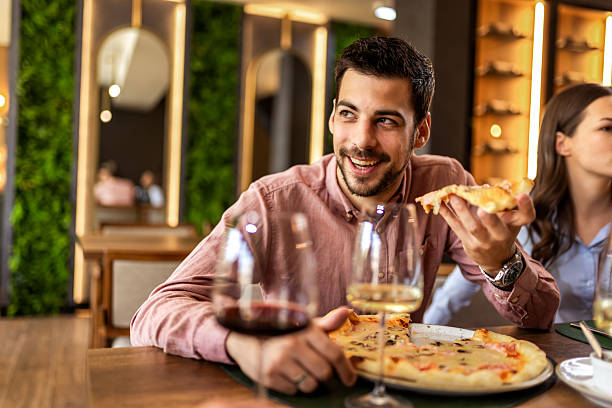 istock Man Eating Pizza with Colleagues at Lunch 2232559606