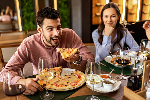 istock Man Eating Pizza with Colleagues at Lunch 2232559645