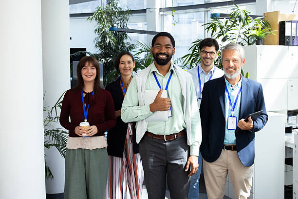 istock Smiling business people standing together in modern office 2232561066