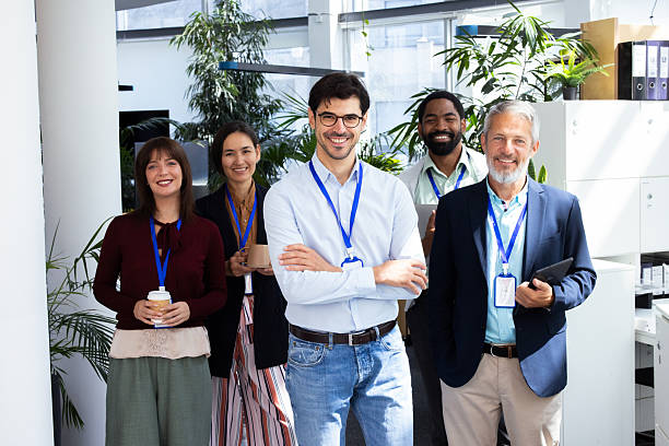 istock Smiling businesspeople wearing lanyards posing in office corridor 2232561068