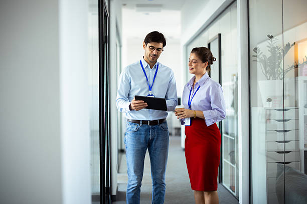 istock Business colleagues walking and talking in office corridor 2232561094