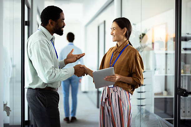istock Business people shaking hands in modern office corridor 2232561106