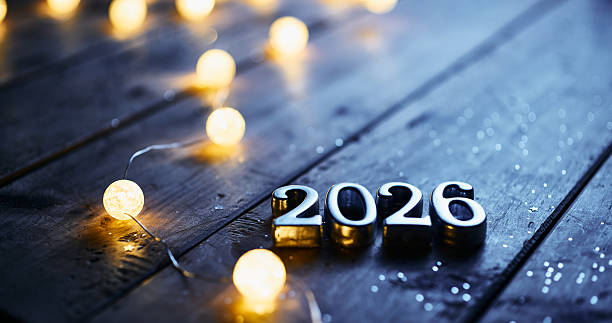 istock Metallic 2026 Numbers with Soft Glowing Lights on Dark Wooden Surface 2232562174