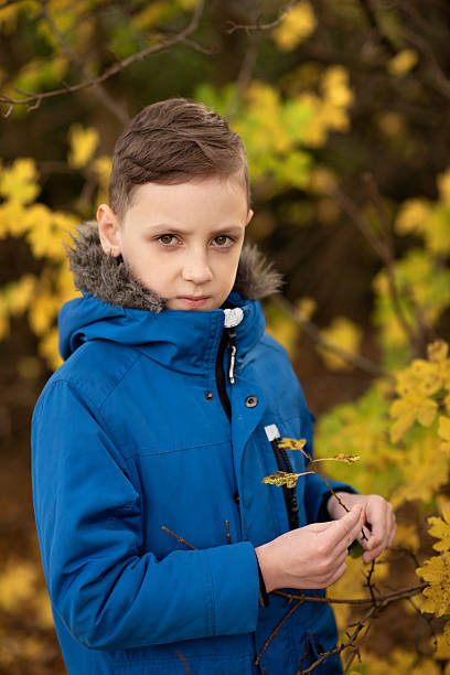 istock Boy in blue jacket in autumn park 2232562570