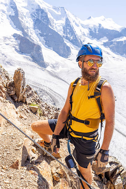 istock Man Ascending a Rocky Via Ferrata with Glacier Backdrop 2232563484