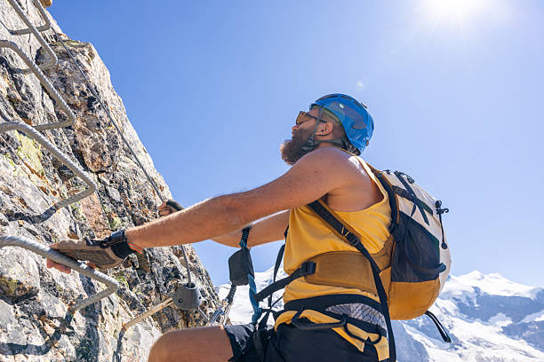 istock Man Climbing Rocky Mountain with Safety Gear 2232563596