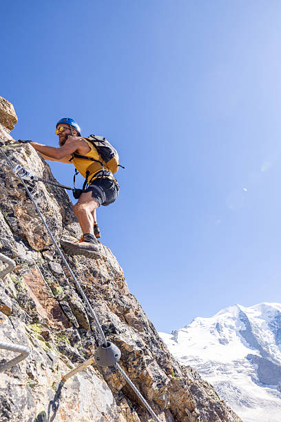 istock Man Climbing Rocky Mountain with Safety Gear 2232563740
