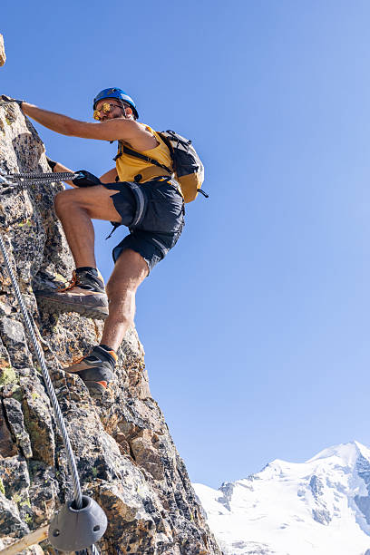 istock Man Climbing Rocky Mountain with Safety Gear 2232563750