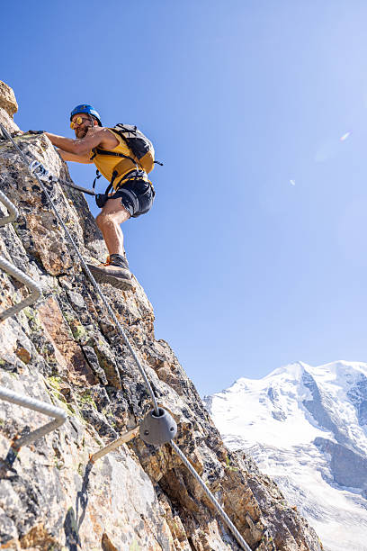 istock Man Climbing Rocky Mountain with Safety Gear 2232563781